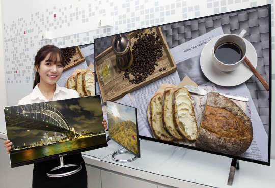 LG전자가 오는 6일부터 열리는 'CES 2015'에서 5개 시리즈 7종의 OLED TV를 선보인다. LG전자 모델이 UHD OLED TV를 소개하고 있다(왼쪽 사진). LG디스플레이 모델이 CES2015에서 선보일 OLED 제품들을 소개하고 있다.   LG전자·LG디스플레이 제공